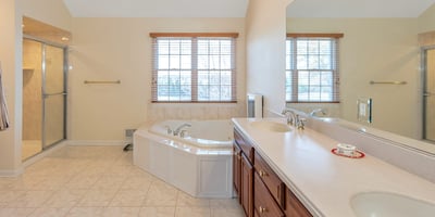 Primary Bathroom has a beautifully tiled shower, high ceiling with recessed lighting, and natural light.
