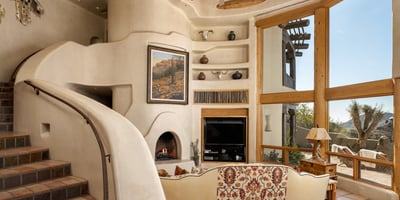 Towering wood beam ceilings and expansive glass bring warmth and views to this elegant family space. Centered around a sculptural fireplace, it s the perfect place to relax or entertain with a connection to the outdoors.