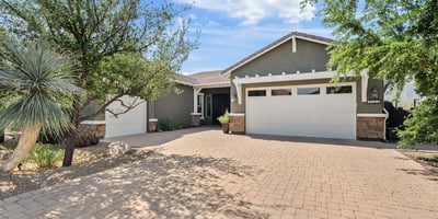 This beautifully designed Phoenix residence showcases stone accents, Craftsman-style architecture, desert landscaping, and a welcoming paver driveway that highlights pride of ownership and timeless design.