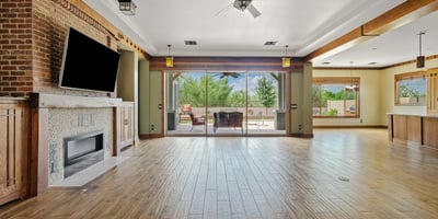 The open floor plan connects living spaces with warmth and elegance, featuring wood floors, beamed ceilings, and seamless transitions ideal for modern Phoenix living.
