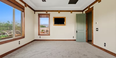 Alternate view of the primary bedroom highlighting tray ceilings, natural light, and refined wood accents. A comfortable and elegant space in this Phoenix home.