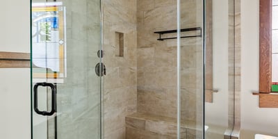 Elegant walk-in shower with detailed tilework, frameless glass, and built-in seating. A spa-like bathroom feature that reflects craftsmanship and modern comfort.