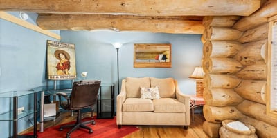 Comfortable bedroom featuring a built-in desk area and seating, offering flexibility for guests, hobbies, or a home office within a rustic setting.