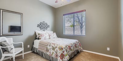 Light-filled guest bedroom with neutral paint, ceiling fan, and closet space, perfect for visitors or daily use.