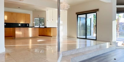 Elegant kitchen and dining area with direct sightlines to the pool and lake. Open layout enhances light and flow for ideal entertaining.