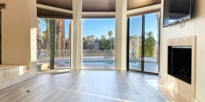 Modern fireplace surrounded by expansive windows and tranquil lake views. A peaceful retreat for both comfort and style.