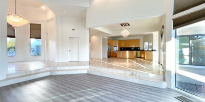 Expansive main living space framed by large windows, marble flooring, and designer chandeliers blending comfort and architectural grace.
