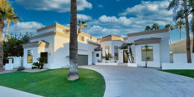 Stunning front approach with a grand circular driveway, manicured landscape, and contemporary exterior finishes.