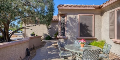 Gather under the Arizona sun in this inviting front patio with privacy walls and mature trees. A perfect outdoor retreat for morning coffee or evening relaxation.