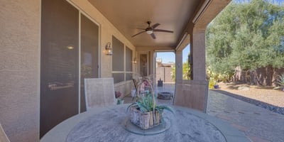 Shaded patio with ceiling fan comfort and lush landscaping backdrop. A perfect place to unwind and savor Arizona s year-round sunshine.