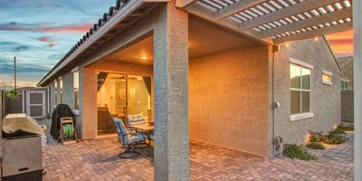 Soft lighting enhances the covered patio and pergola, creating a warm, inviting outdoor dining and relaxation area in Litchfield Park.