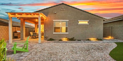 The backyard glows with warm lighting, updated landscaping, and a charming pergola, creating an inviting outdoor haven in Litchfield Park.
