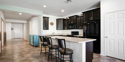 Functional kitchen with expansive island seating, dark cabinetry, and open sightlines to the living areas for effortless entertaining.