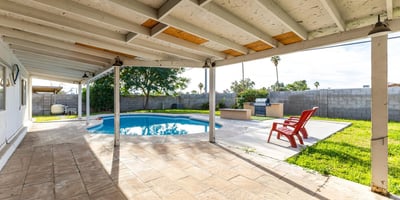 View from the patio doorway highlighting the private pool, covered patio, and outdoor entertaining space your own Phoenix backyard escape made for gatherings and relaxation.