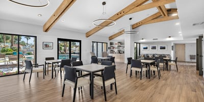 Expansive clubhouse interior with dining tables and lounge areas, ideal for hosting and connecting with neighbors.