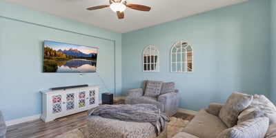 Front living room featuring soft natural light, updated flooring, and comfortable seating space perfect for relaxing or welcoming guests.