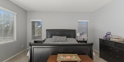 Bright primary bedroom with neutral finishes, ceiling fan, and expansive floor space offering comfort and versatility within the home s upper level.