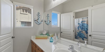 Clean and functional bathroom featuring a vanity with storage, large mirror, and shower tub combination designed for everyday convenience.