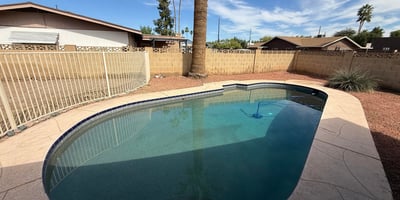 Private Pebble Tec pool surrounded by desert landscaping and tall palm trees. The backyard offers a peaceful outdoor retreat ideal for enjoying Glendale s sunny climate.