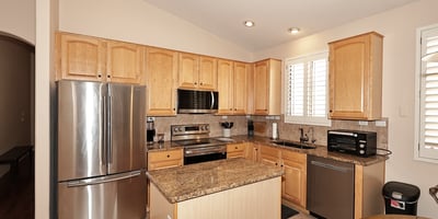 Kitchen with abundant cabinetry, granite surfaces, and stainless steel appliances. This Phoenix property offers both style and storage for modern living.