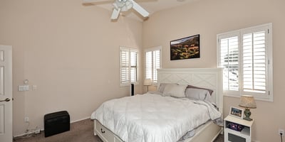 Comfortable primary suite with large windows, soft carpet, and open layout. This Phoenix home provides a relaxing retreat with functional space and natural light.