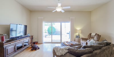Light-filled living room with sliding doors to the backyard patio, hardwood floors, and open layout for comfortable living.