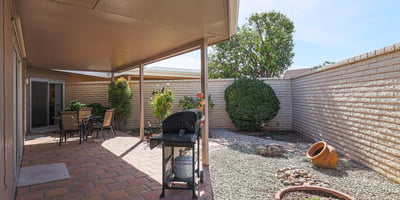 Low-maintenance backyard with desert landscaping, privacy walls, and covered patio, offering a peaceful outdoor retreat.