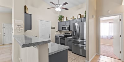 Open kitchen featuring breakfast bar, durable countertops, and included appliances ideal for casual meals and hosting.