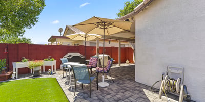 Inviting backyard with artificial turf, patio seating, and landscaped accents. Designed for entertaining and low-maintenance living.