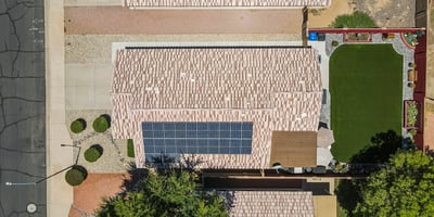 Top-down view displaying the home s footprint, solar system, and spacious backyard with turf and patio areas in Surprise.