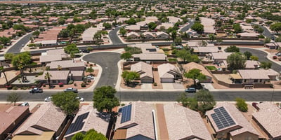 Sweeping aerial view of the neighborhood featuring organized streets, nearby homes, and distant mountain scenery, offering a sense of location and community.