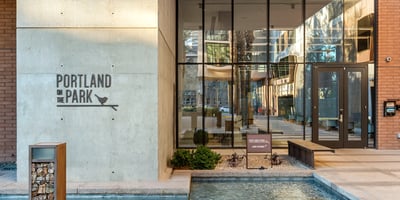 Elegant lobby with glass entry doors, clean lines, and landscaped accents, offering a welcoming arrival experience in Phoenix.