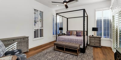 Spacious bedroom retreat with modern finishes, wood flooring, and natural light, offering comfort and privacy in this Phoenix home.