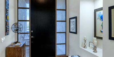 Modern entry with tall ceilings, wood flooring, and striking front door design, creating a welcoming arrival experience in Phoenix.