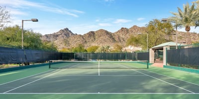 Community tennis court set against scenic mountain views, offering recreational amenities in this Phoenix neighborhood.