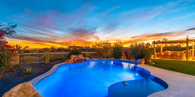 Scottsdale backyard illuminated at sunset with pool, spa, and outdoor kitchen, creating the perfect space for entertaining and relaxing evenings.