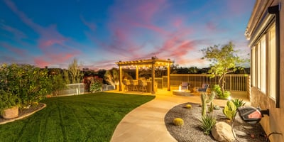 Beautifully designed Scottsdale backyard with manicured grass, desert landscaping, and pergola space ideal for relaxing or entertaining.