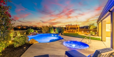 Stunning backyard oasis with pool, spa, pergola, and desert landscaping, showcasing Scottsdale luxury outdoor living during golden hour.