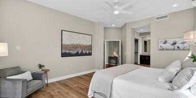 Open and airy Scottsdale bedroom featuring wood floors, large layout, and seamless flow into the ensuite bathroom.