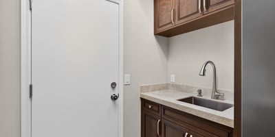 Efficient Scottsdale laundry room with built-in cabinetry, sink, and counter space for added convenience and organization.