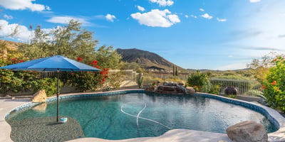 Scottsdale backyard with custom pool, rock water feature, and mountain views, creating a relaxing and private outdoor space.