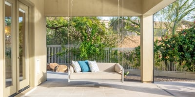 Scottsdale outdoor living space with hanging swing bench, tiled patio, and serene backyard views.