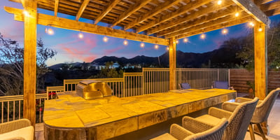 Scottsdale backyard featuring a pergola-covered bar with seating and string lights, perfect for entertaining guests.
