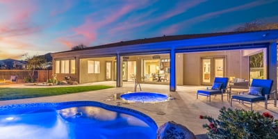 Scottsdale outdoor space with illuminated spa, covered patio, and poolside seating, ideal for relaxing evenings.
