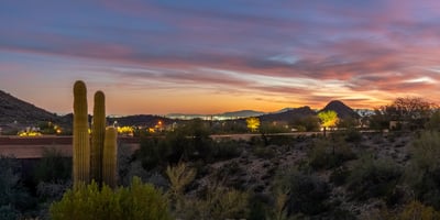 Scottsdale desert scenery with saguaro cacti, rolling hills, and colorful sunset skies, offering a peaceful and picturesque setting.
