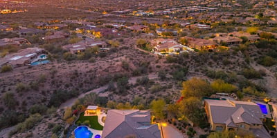 Scottsdale aerial capturing expansive desert views, surrounding homes, and vibrant sunset colors.