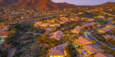 Scottsdale aerial view of the community with desert surroundings, mountain views, and glowing evening ambiance.