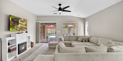 Light-filled living room with fireplace and direct access to the backyard pool area. Open design creates a welcoming space for relaxing or entertaining in this Casa Grande home.