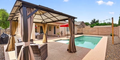 Backyard featuring a private pool and shaded pergola lounge area. Ideal for entertaining and enjoying warm Casa Grande evenings.