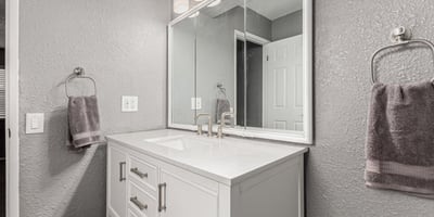 Well-lit vanity area with updated cabinetry and modern mirror. This Sun City home features upgraded bathrooms and functional design.